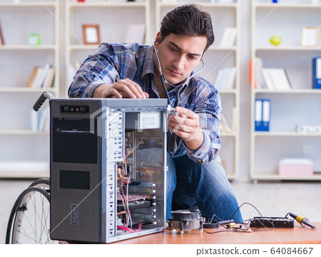 Disabled man on wheelchair repairing computer 64084667