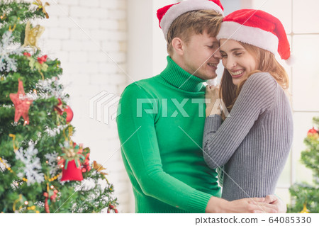 Couple celebrating Christmas. Man hugging woman.. Couple celebrating Christmas. Man hugging woman.. 64085330