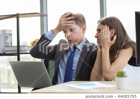 Boss and co-worker looking at notebook screen.. Boss and co-worker looking at notebook screen.. 64085705