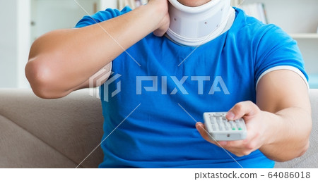 Man with neck injury watching football soccer at home Man with neck injury watching football soccer at home 64086018