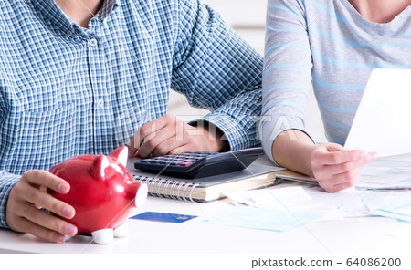 Young couple looking at family finance papers Young couple looking at family finance papers 64086200