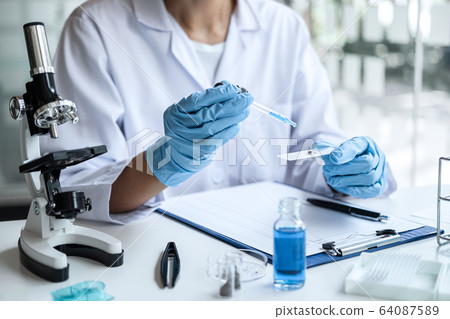 Scientist or medical in lab coat holding test tube 64087589
