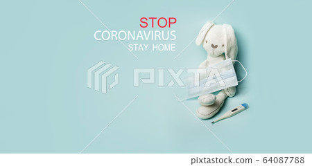 Medical masks with bunny toy and thermometer on blue background. Stop coronovirus text. Banner. Safe in home. 64087788