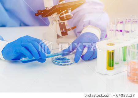 Scientist medical lab technician mixing chemical solution for reaction observing 64088127