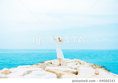 A woman standing on the coast A woman standing on the coast 64088143