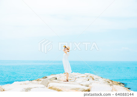 A woman standing on the coast 64088144