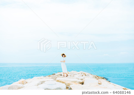 A woman standing on the coast 64088146