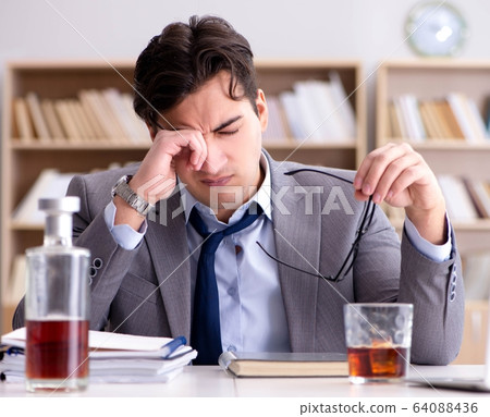 Young businessman drinking from stress 64088436