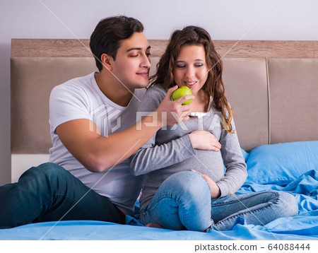 Young family with pregnant wife expecting baby in bed 64088444