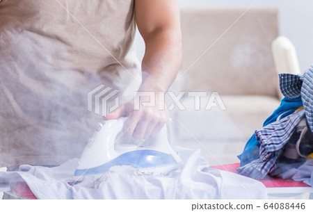 Inattentive husband burning clothing while ironing 64088446