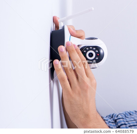 Man installing surveillance CCTV cameras at home Man installing surveillance CCTV cameras at home 64088579