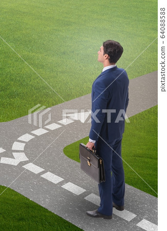 Young businessman at crossroads in uncertainty concept 64088588