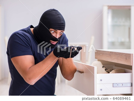 Robber wearing balaclava stealing valuable things Robber wearing balaclava stealing valuable things 64089461