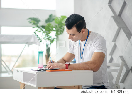 Professional skilled male doctor writing in his notebook 64089594