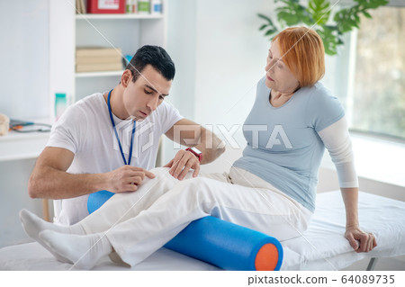 Pleasant senior woman having her legs treated 64089735