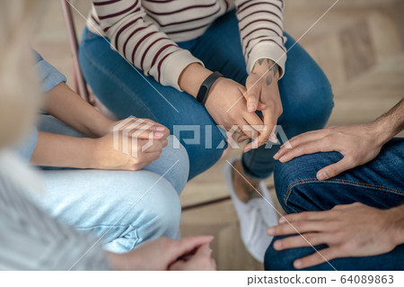 Group of people sitting in a circle close to each other Group of people sitting in a circle close to each other 64089863
