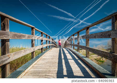 Woman in pink clothes over wooden bridge Woman in pink clothes over wooden bridge 64090363
