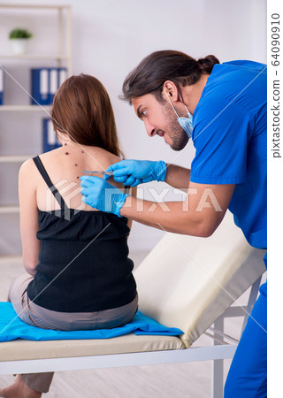 Young woman visiting male doctor dermatologist 64090910