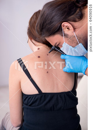 Young woman visiting male doctor dermatologist 64090916