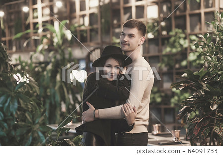 loving couple embraces in cafe 64091733