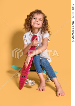 Active and happy Kid having fun with penny board, smiling face stand skateboard. Penny board cute skateboard for girls. Lets ride. Girl ride penny board yellow background. Summer vacation Active and happy Kid having fun with penny board, smiling face stand skateboard. Penny board cute skateboard for girls. Lets ride. Girl ride penny board yellow background. Summer vacation 64091847