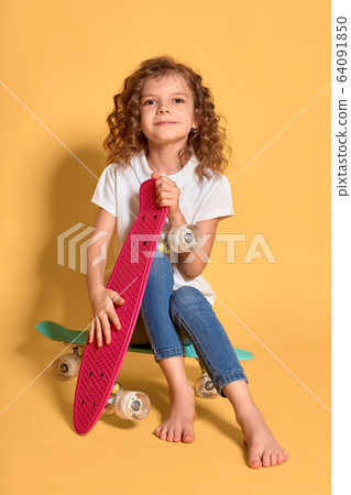 Active and happy Kid having fun with penny board, smiling face stand skateboard. Penny board cute skateboard for girls. Lets ride. Girl ride penny board yellow background. Summer vacation Active and happy Kid having fun with penny board, smiling face stand skateboard. Penny board cute skateboard for girls. Lets ride. Girl ride penny board yellow background. Summer vacation 64091850