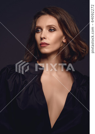 Portrait of beautiful brunette woman in black dress. Fashion photo 64092272