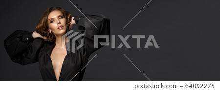 Portrait of beautiful brunette woman in black dress. Fashion photo 64092275