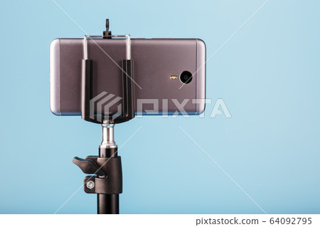 The smartphone is mounted on a tripod as a The smartphone is mounted on a tripod as a 64092795