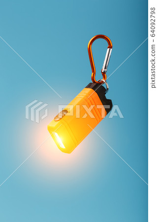 Orange led Flashlight with a carabiner on a blue Orange led Flashlight with a carabiner on a blue 64092798
