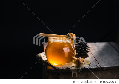 Honey in a glass jar,Scoop the honey in a glass Honey in a glass jar,Scoop the honey in a glass 64093005
