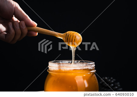 Honey in a glass jar,Scoop the honey in a glass Honey in a glass jar,Scoop the honey in a glass 64093010