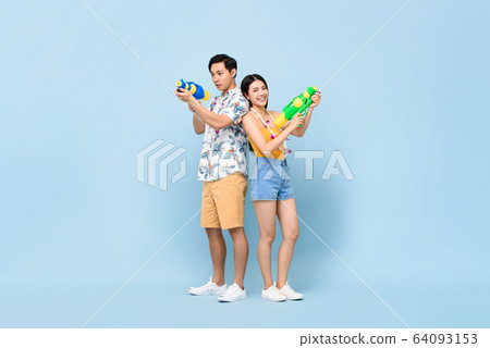 Young Asian couple in summer outfits with water guns 64093153
