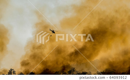Helicopter dropping water on forest fire Helicopter dropping water on forest fire 64093912