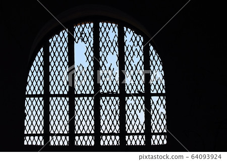 Rusty metallic bars with wire in the window 64093924
