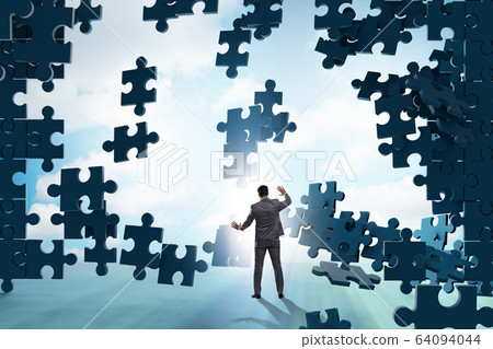 Businessman breaking the wall of jigsaw puzzle Businessman breaking the wall of jigsaw puzzle 64094044