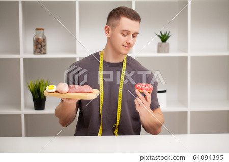 Trainer consumes a high-protein meal of meat and fruit 64094395