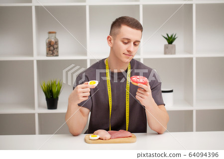 Trainer consumes a high-protein meal of meat and fruit 64094396