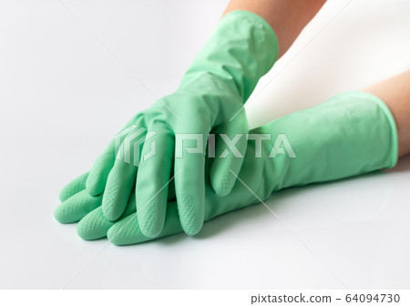 Hand in green latex dishwashing gloves on a white background 64094730