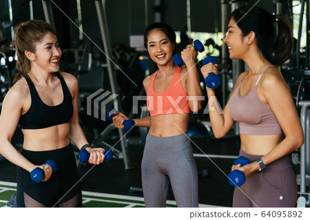 Cheerful diverse group of sportswomen exercising in gym 64095892