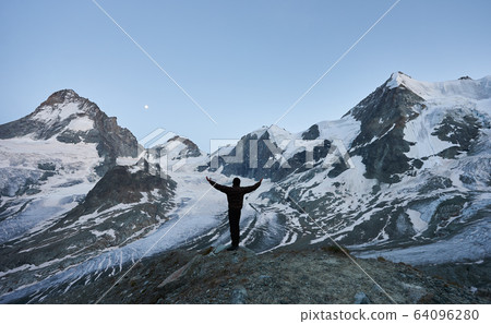 Traveller enjoying incredible starry night in the mountains in Switzerland Alps 64096280