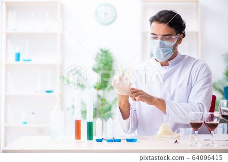 Male chemist examining wine samples at lab Male chemist examining wine samples at lab 64096415