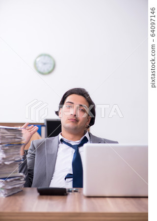 Young male employee unhappy with excessive work Young male employee unhappy with excessive work 64097146