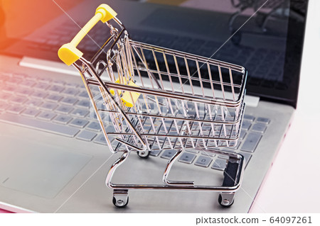 Small shopping trolley standing on laptop keyboard 64097261