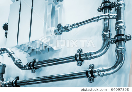 wiring of radiator pipes in the room on the wall 64097898