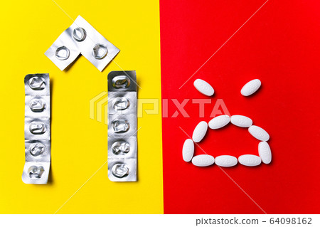 Colored pills, tablets and capsules on a red and yellow background - history of treatment, prevention of pandemic Colored pills, tablets and capsules on a red and yellow background - history of treatment, prevention of pandemic 64098162