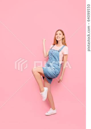 Happy attractive young girl shows victory gesture Happy attractive young girl shows victory gesture 64099550