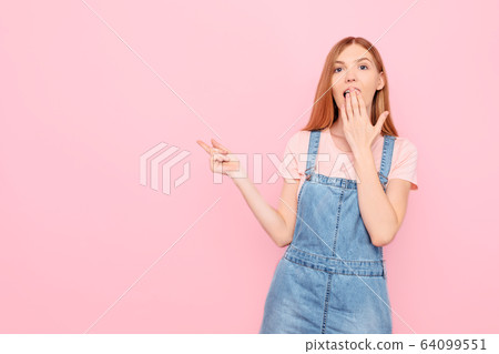 Shocked young girl pointing her finger at a copy Shocked young girl pointing her finger at a copy 64099551
