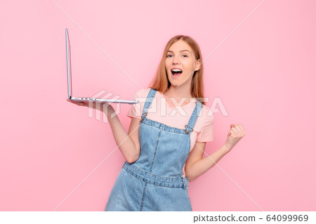 Portrait of a shocked girl holding a laptop and Portrait of a shocked girl holding a laptop and 64099969