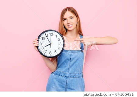 young girl with a watch in her hands, on an young girl with a watch in her hands, on an 64100451